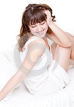 Young woman sitting in the white bed