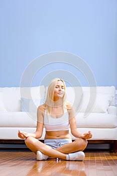 Young Woman Sitting on Wood Floor Meditating