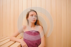 Beautiful woman relaxing in sauna and staying healthy