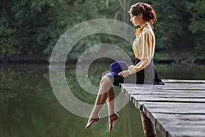 Young woman sitting on wooden bridge
