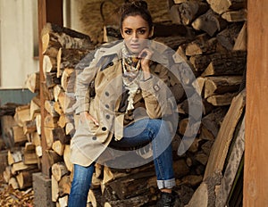 Young woman sitting in woodshed