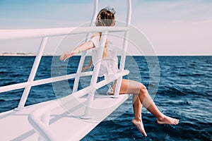 Young woman sitting on the yacht deck enjoying the moment on a sunny day. Copy space