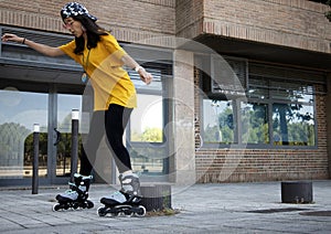 Young woman skating on the street dodging bollards