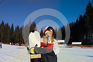 Young woman with ski mask holding snowboard outdoor