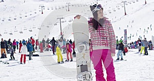 Young woman on ski slope with snowboard