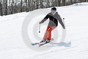 Young woman skier coming down the slope on sunny day