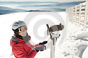 Young woman skier at winter ski resort in mountains reading map, finding path