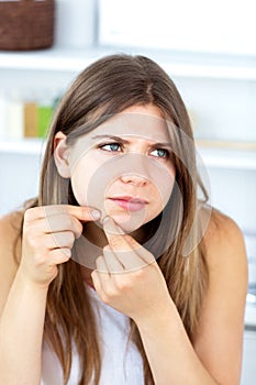Young woman with skin irritation cleaning her face