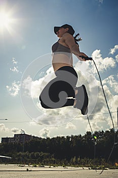 Young woman skipping rope outdoors