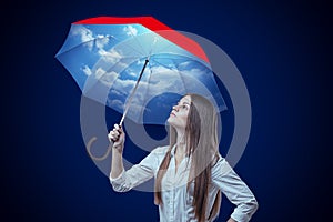 Young woman with sky design umbrella on dark blue background