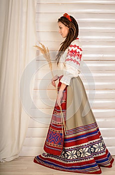 Young woman in Slavic Belarusian national original suit studio