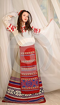 Young woman in Slavic Belarusian national original suit studio