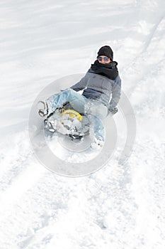 Young woman sledging in the deep snow