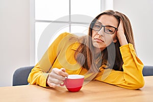 Young woman sleeped drinking coffee at office photo