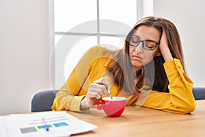 Young woman sleeped drinking coffee at office photo