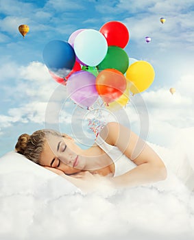 Young woman sleeping in bed. Bright air balloons in blue cloudy sky - sweet dreams