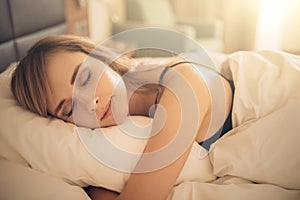 Young woman sleeping in bed. Morning