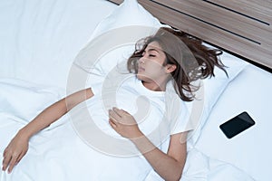 Young Woman Sleeping Cozily and Holding Phone