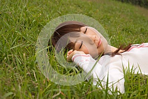 Young woman sleeping on grass