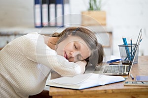 Young woman sleeping on office desk