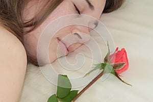 Young woman sleeping and a rose