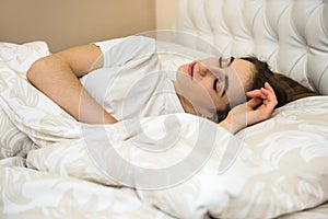 Young  woman sleeping and viewing her sweet dream in  bed and relaxing in the morning before work week. Healthcare and sleep