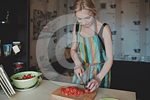 Young woman slicing tomatoes