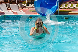 the young woman slid off the waterslide into the pool and laughs