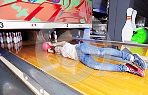 Young woman sliding down a bowling alley