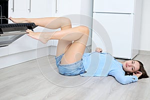 Young woman with slim legs in kitchenette