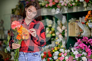 Young woman, small business, florist arranging plants in flower shop