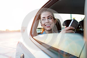 Woman with phone on the back seat of a car photo