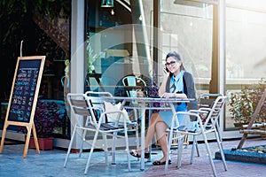 Young woman with smartphone in coffee shop