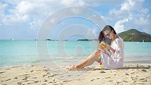 Young woman with smartphone on tropical beach vacation.