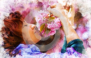 Young woman smelling a beautiful sakura blossom, purple flowers. Spring Magic.