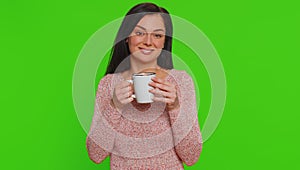 Young woman smelling drinking cup of beverage hot coffee or aroma tea, taking a break, relaxing