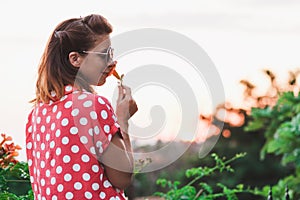 Young woman smelling flower in the garden