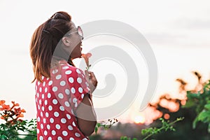 Young woman smelling flower in the garden