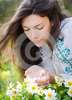 Young woman smelling flowers.