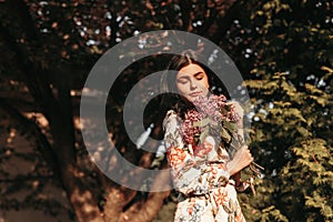 Young woman smelling flowers in park