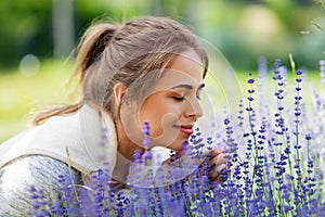 Young woman smelling lavender flowers in garden