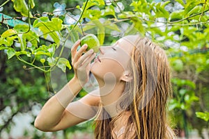 Young woman smelling the passion fruit in the garden