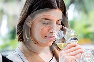 Young woman smelling white wine at tasting.