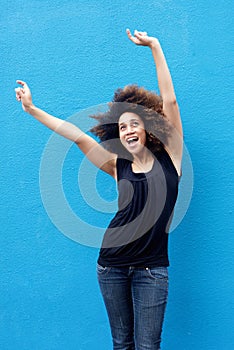 Young woman smiling with arms raised