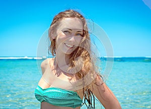 Young woman smiling at camera in front of sea