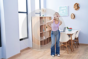 Young woman smiling confident listening to music and dancing at home