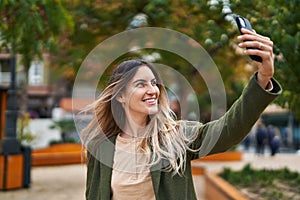 Young woman smiling confident making selfie by the smartphone at park
