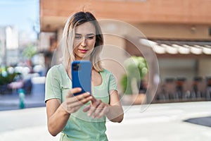 Young woman smiling confident making selfie by the smartphone at street