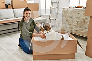 Young woman smiling confident playing with dog at home