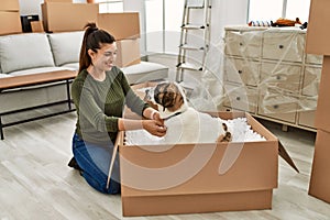Young woman smiling confident playing with dog at home